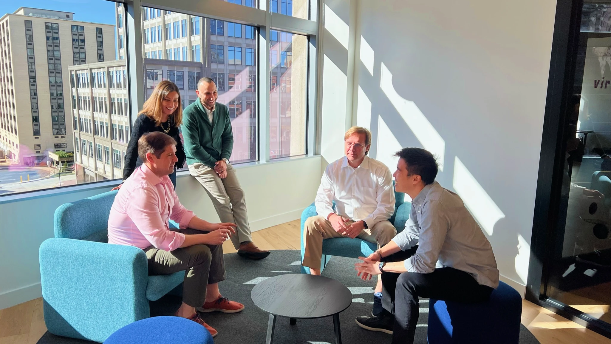 Group of Simatree coworkers sitting around a table discussing business and strategy.